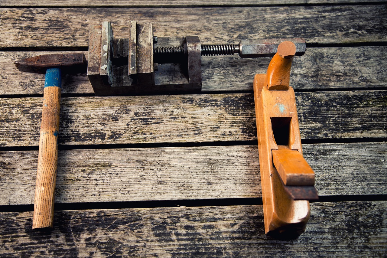 The hand tools used throughout the series — hammer, clamp, and block plane.